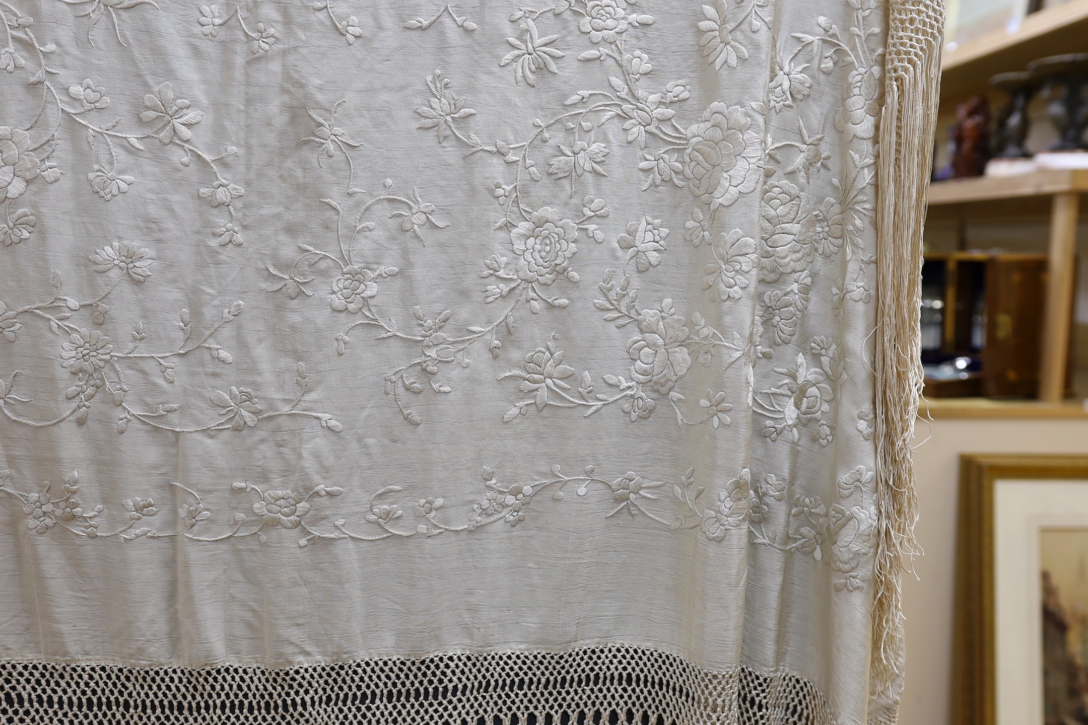 A Chinese late 19th century silk embroidered shawl, with cream on cream embroidery and a cream silk fringe, 140x134 cms